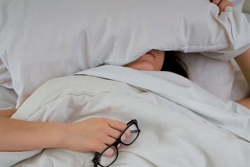 woman laying sick in bed